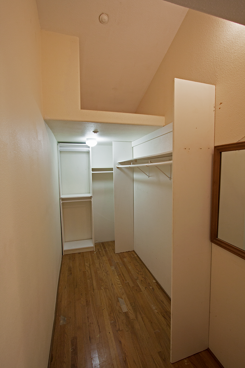 Walk-in closet with additional storage above.