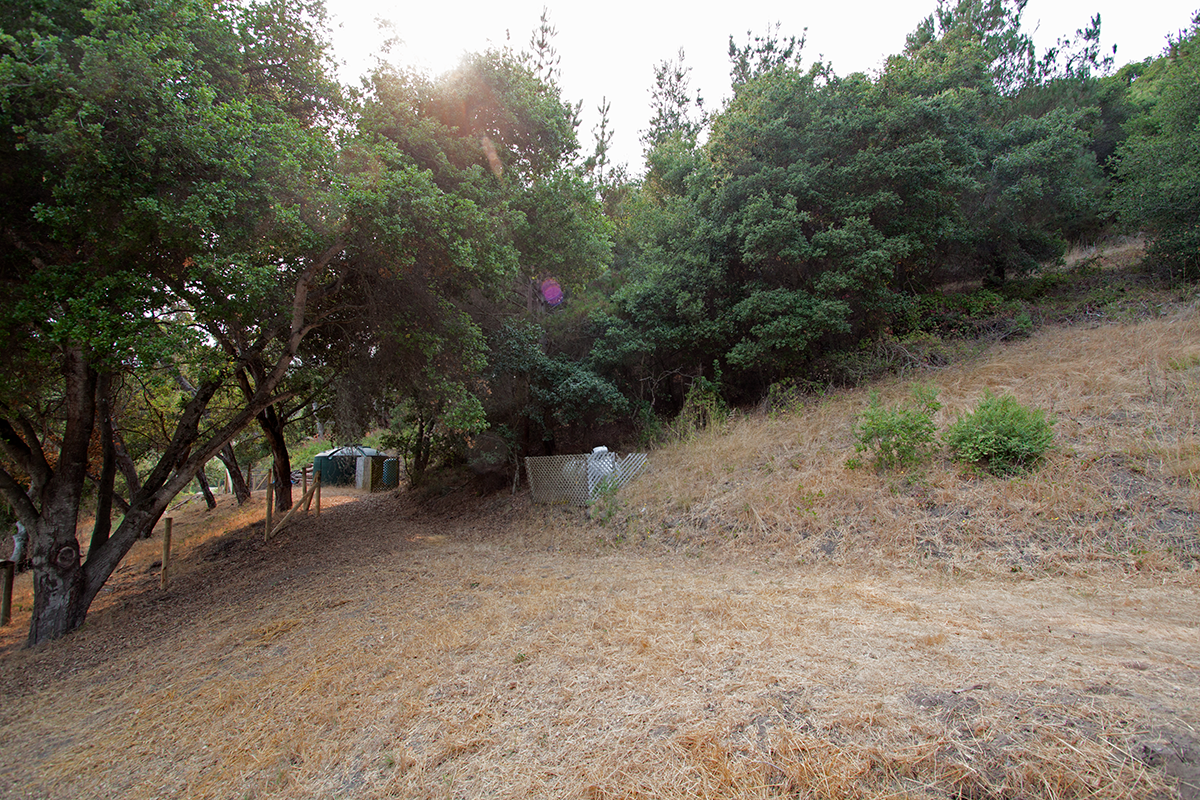 Hills above are covered with oak trees and trails.