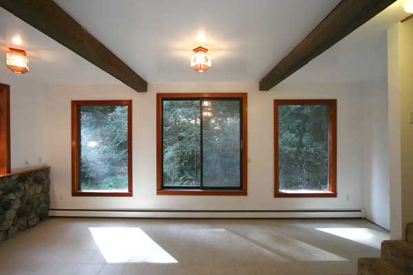 Basement family room with wood stove and creek views.