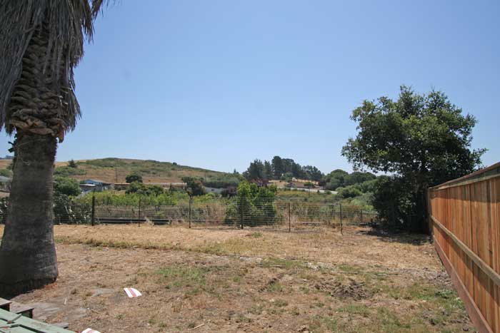 Fenced back yard with gate to pasture.