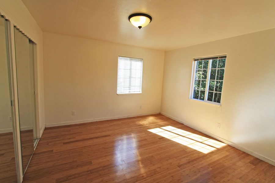 Primary bedroom with bamboo flooring; miniblinds throughout.