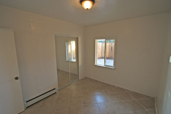Bedroom with patio window and large closet.