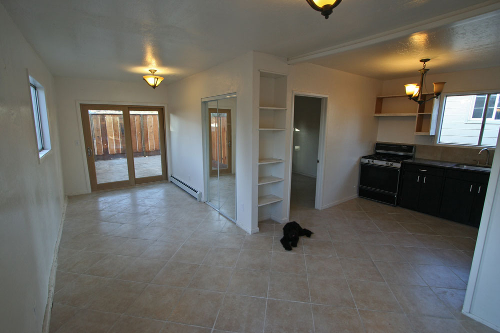 Spacious living room; bedroom at right; patio doors to outside.