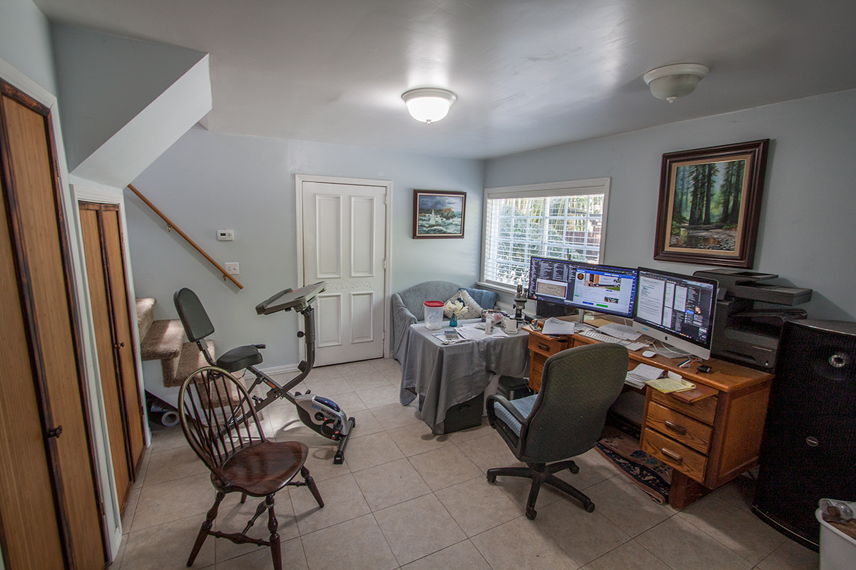 Lower level living/office ~12×14 with tile floor; bedroom at far end.