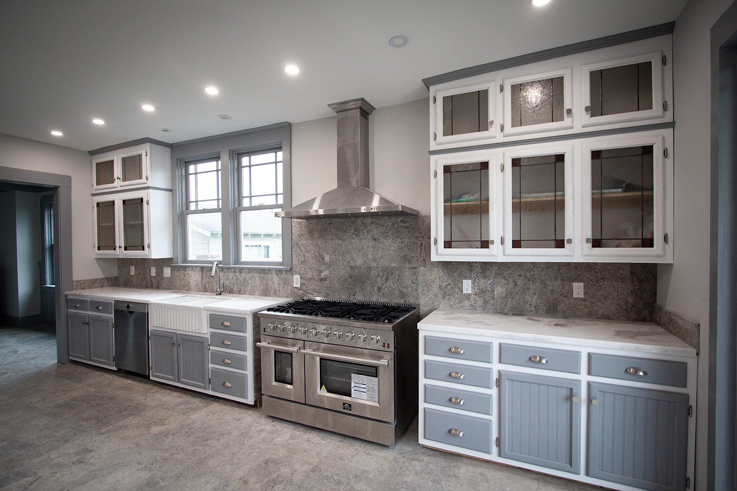 Spacious kitchen with Italian dual-fuel range, granite, and stained glass cabinets.