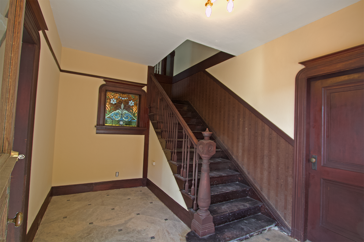 Front hall: original unpainted trim; master BR right, living room left.