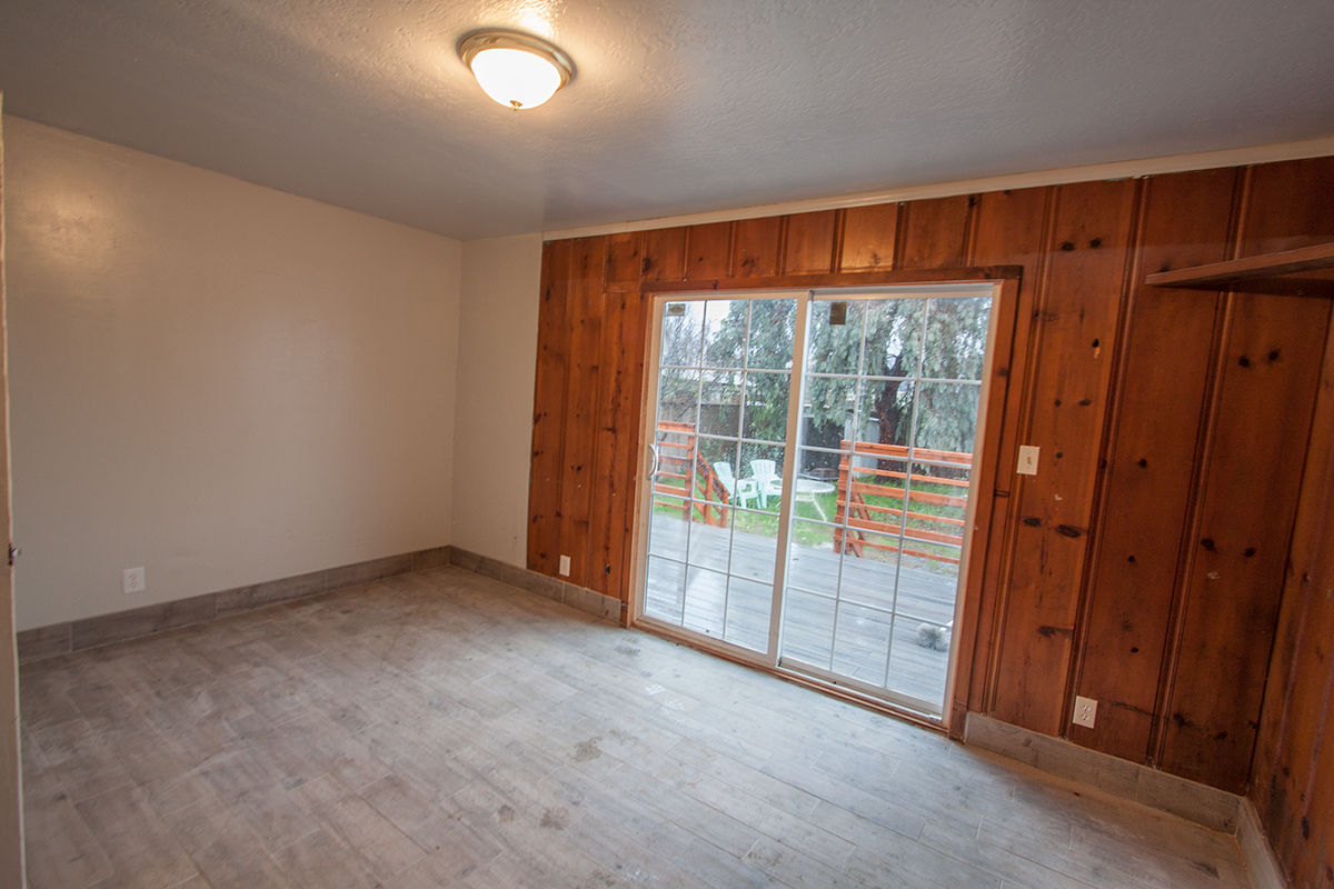 Downstairs bedroom ~11×15 with deck access and knotty pine accents.