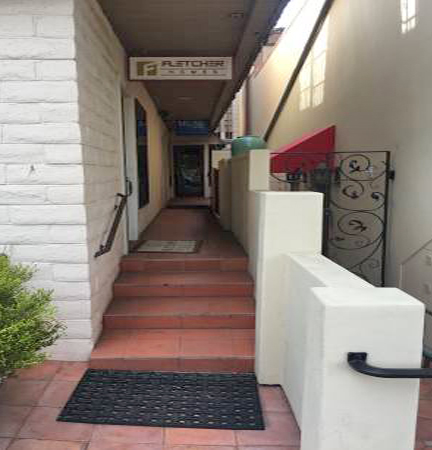 Glass door at end on left; sign visible from street.